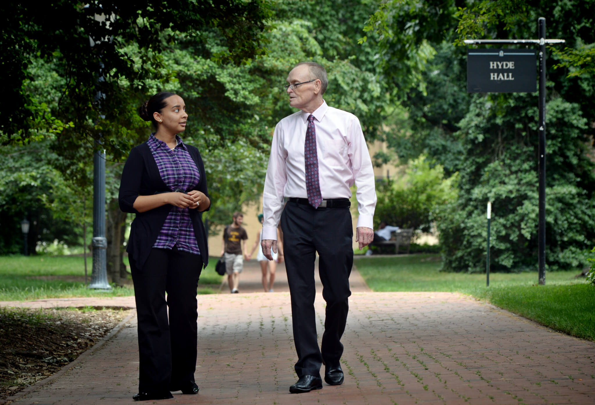 Precious Barnes and Fred Clark walk on a path at UNC-Chapel Hill