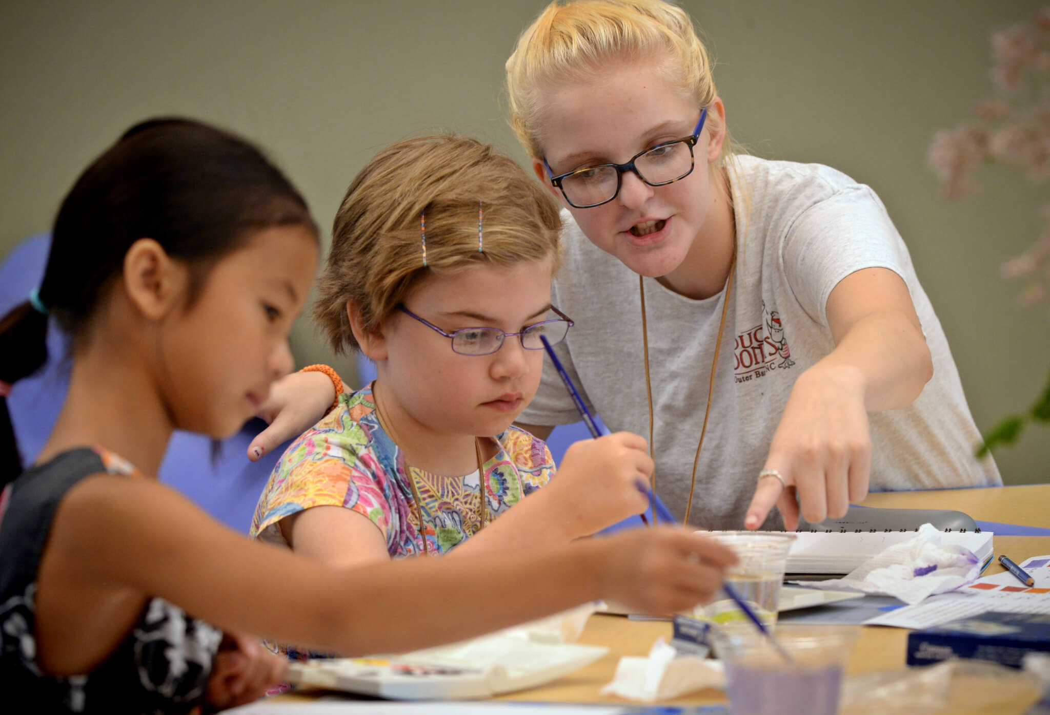 Ada Stewart gets instruction from Counselor in training Jenna Smith helps camper Ada Smith with an art project at the Art of Nature summer camp