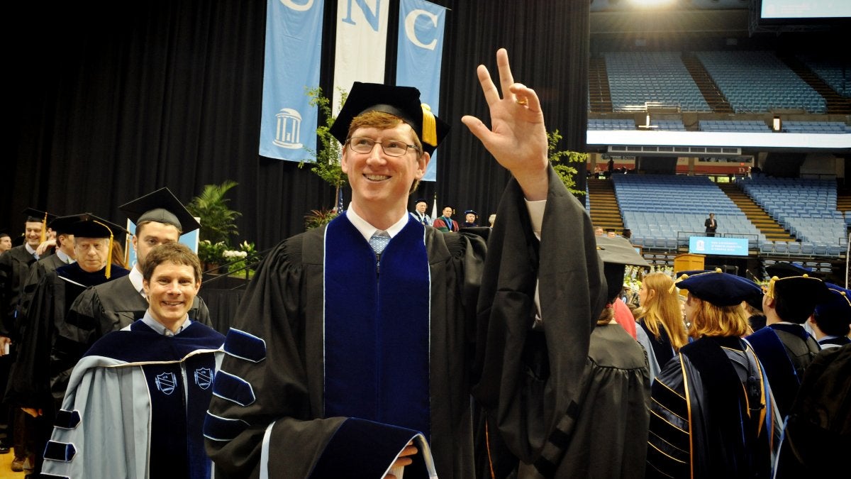A graduate waves to family.