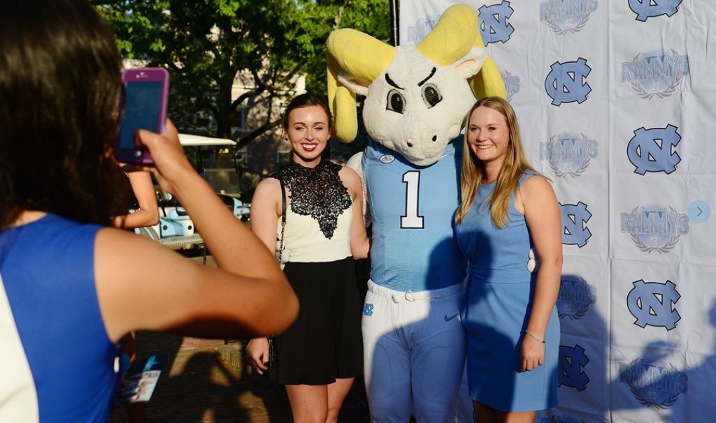 A girl take a photo of two girls with Ramsy.