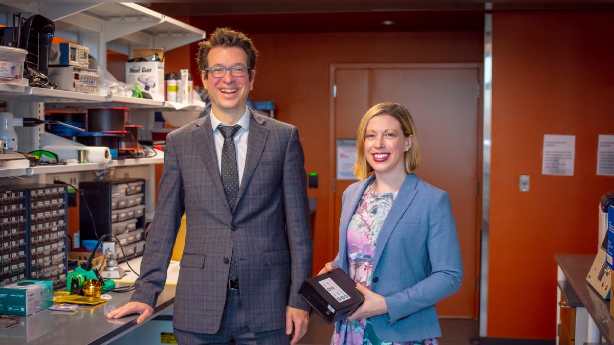 Flavio Frohlich and Leah Townsend standing in a lab.