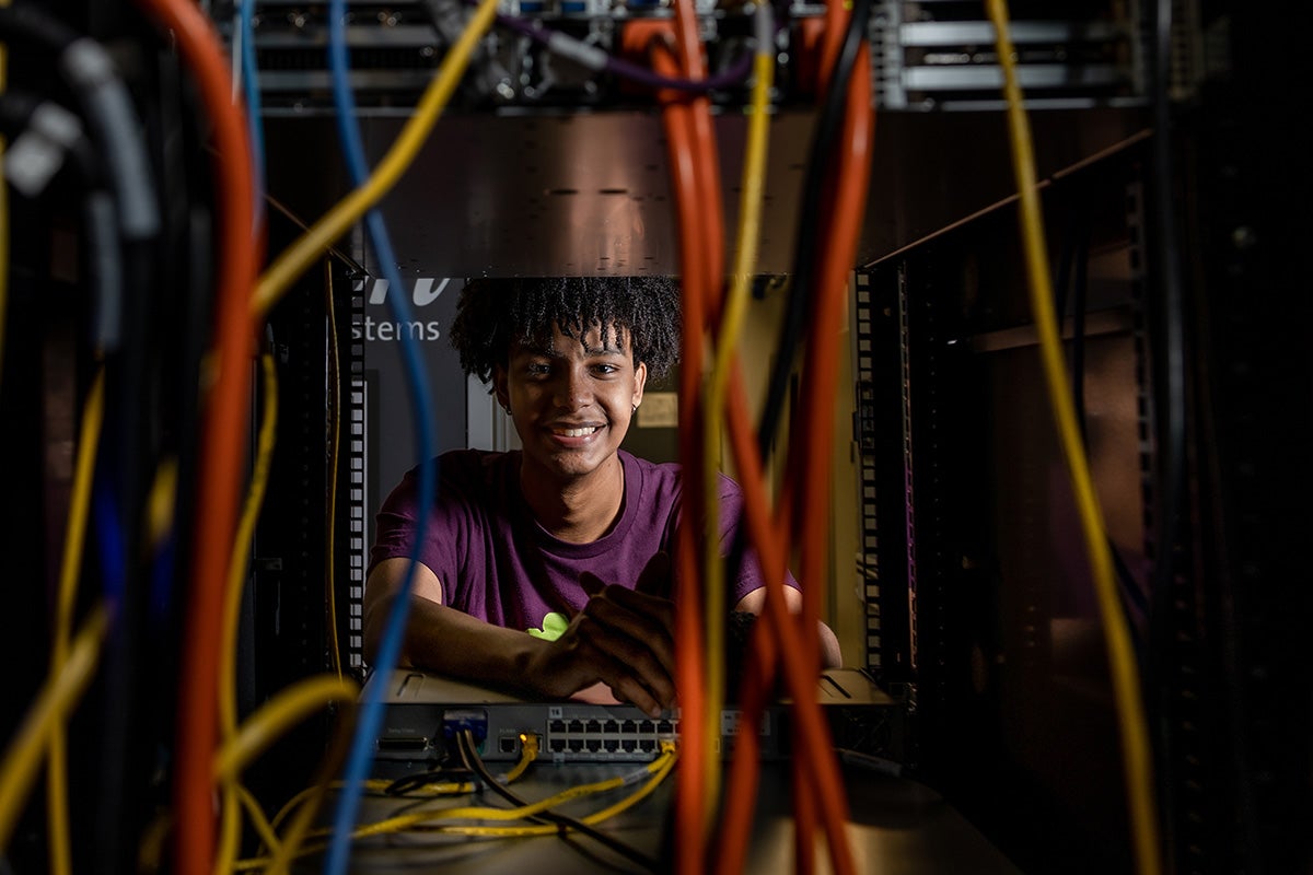 Nathan Kelete looking through a server with cables.