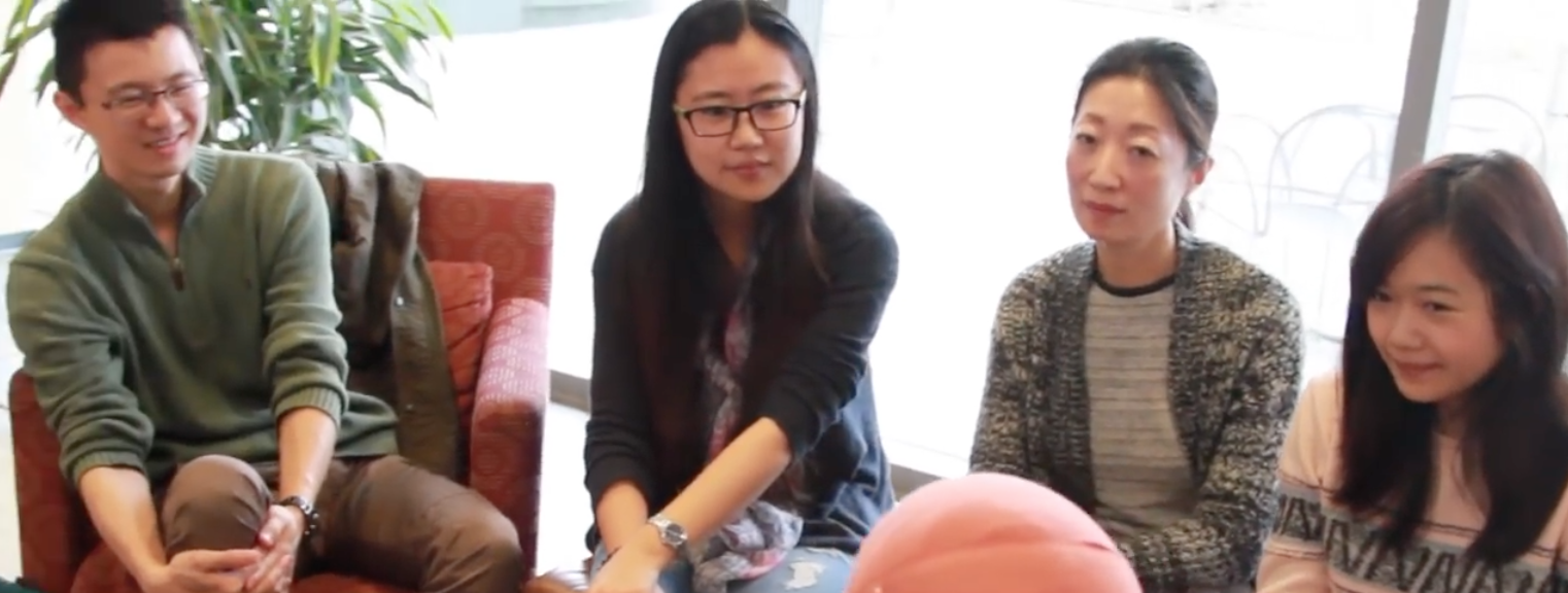 A man and three women sit in chairs and talk