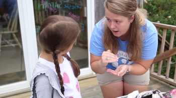 Woman works with young child.