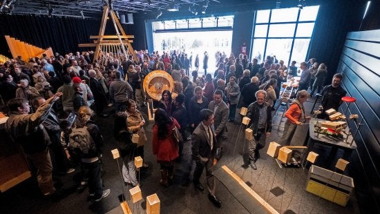 A crowd of people walks through CURRENT ArtSpace