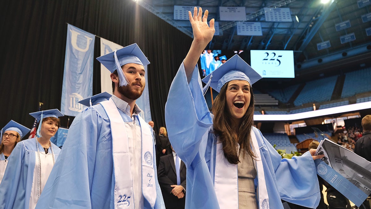 A student waves at graduation.