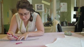 A female student measures fabric.