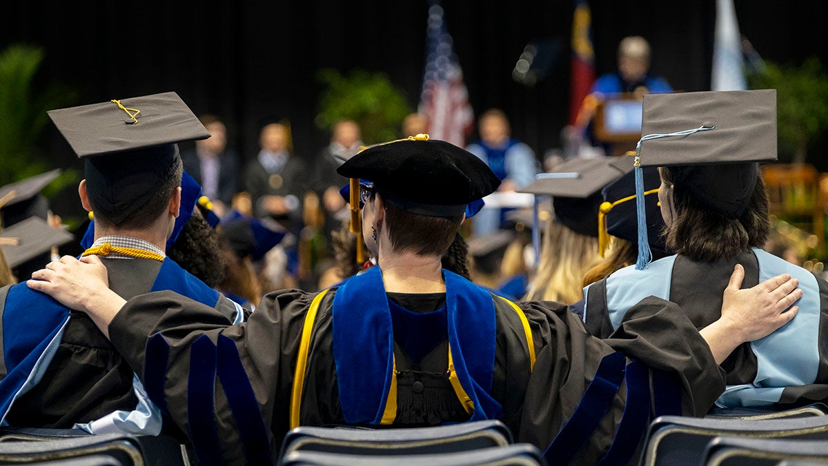 Graduates sitting at the Doctoral Hooding Ceremony.