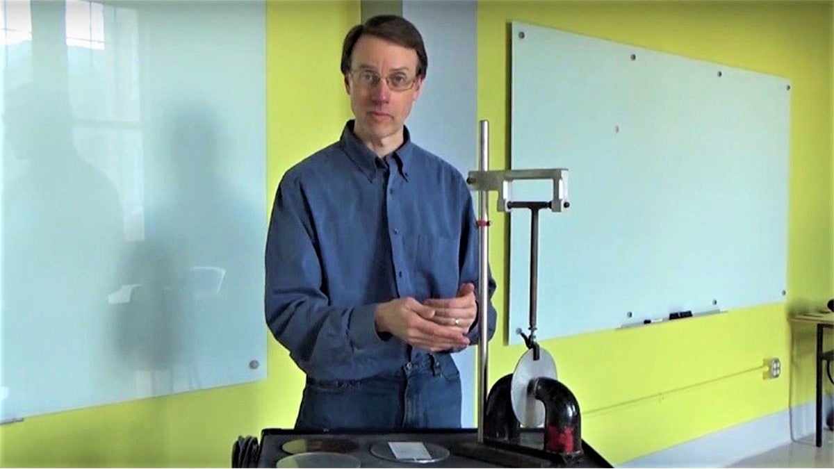 Duane Deardorff stands near a physics experiment.