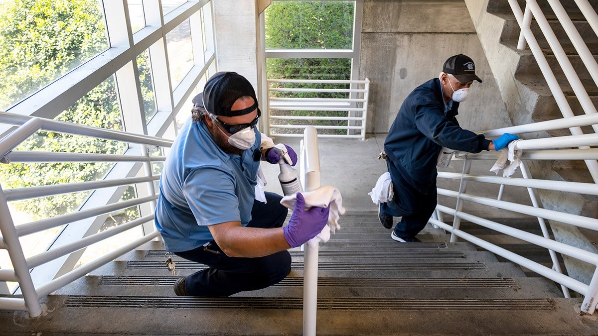 Workers clean stair railings