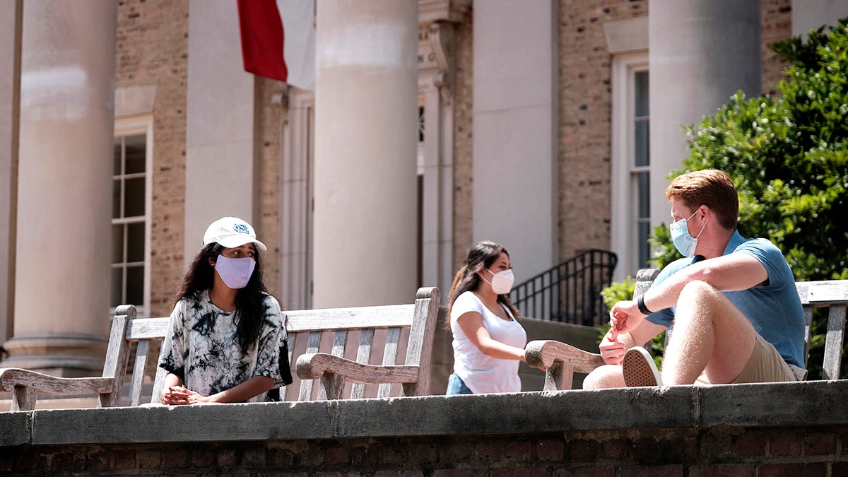 Students wearing masks in front of South Building