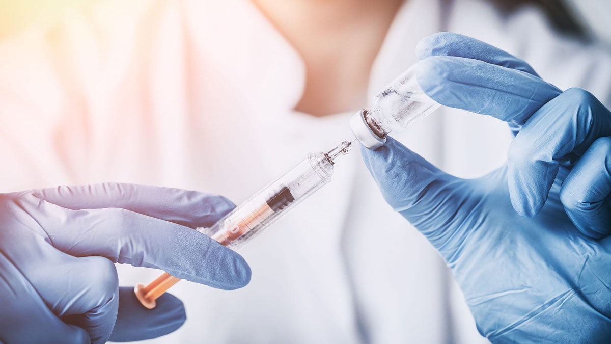 A doctor holds a flu shot.
