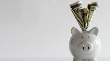 A piggy bank with money coming out of the top.