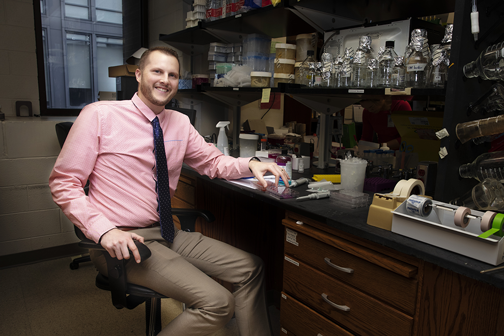 Chad Pecot sits near a lab bench.