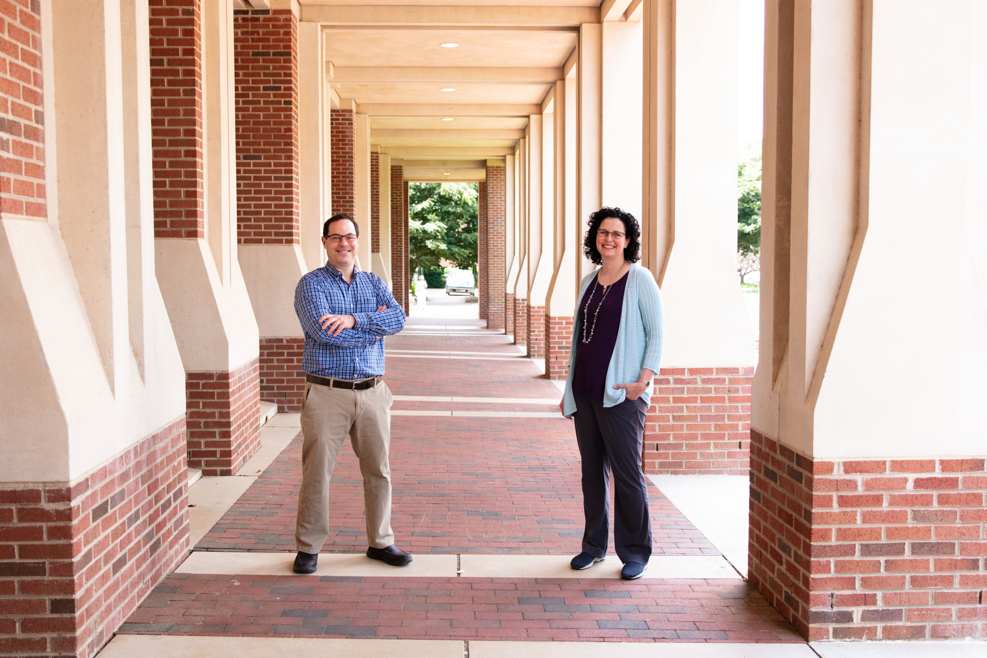 Brian Strahl and Samantha Pattenden stand outside by an academic building.