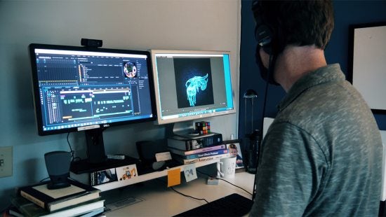 A man working on a computer with two screens