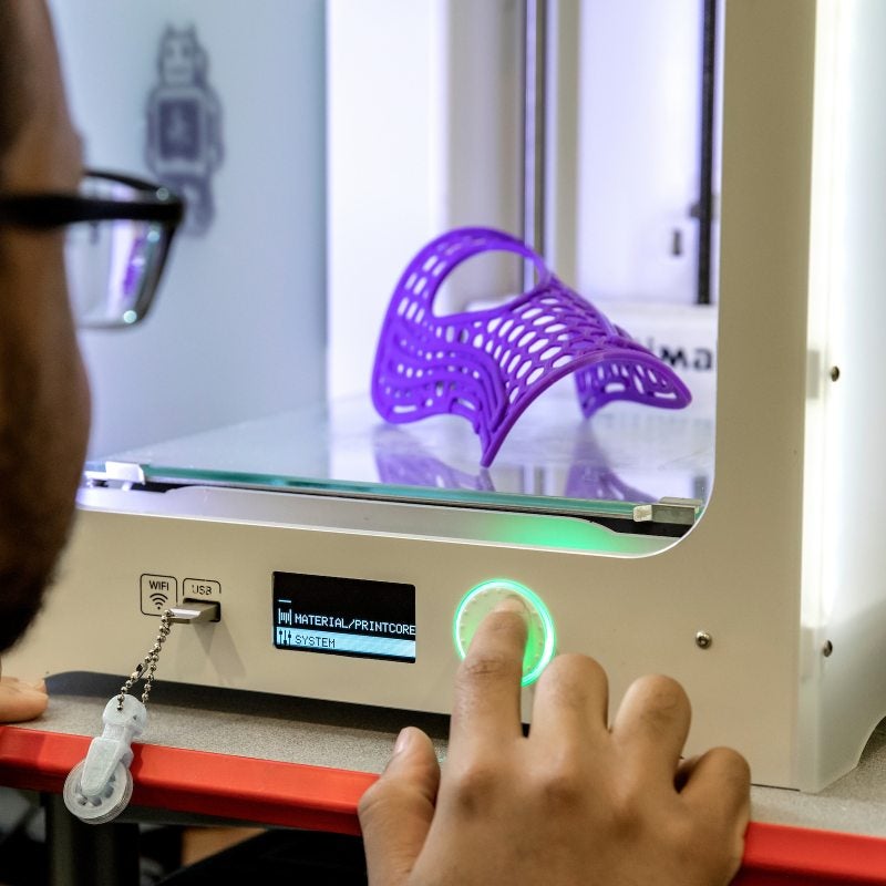 A person uses a 3D printer.