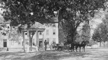 A black and white photo of a man at the Old Well.