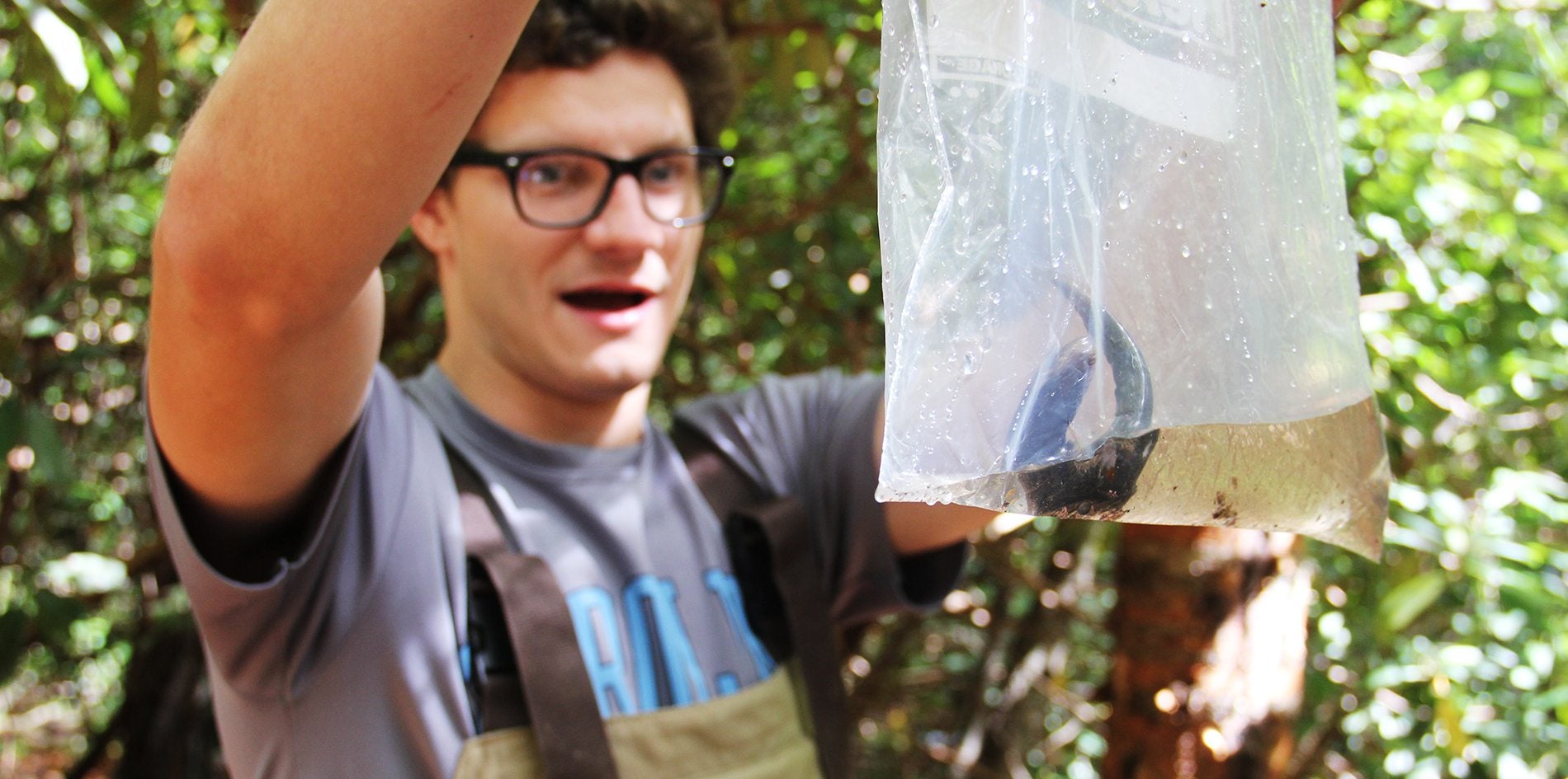A student with a salamander in a bag.