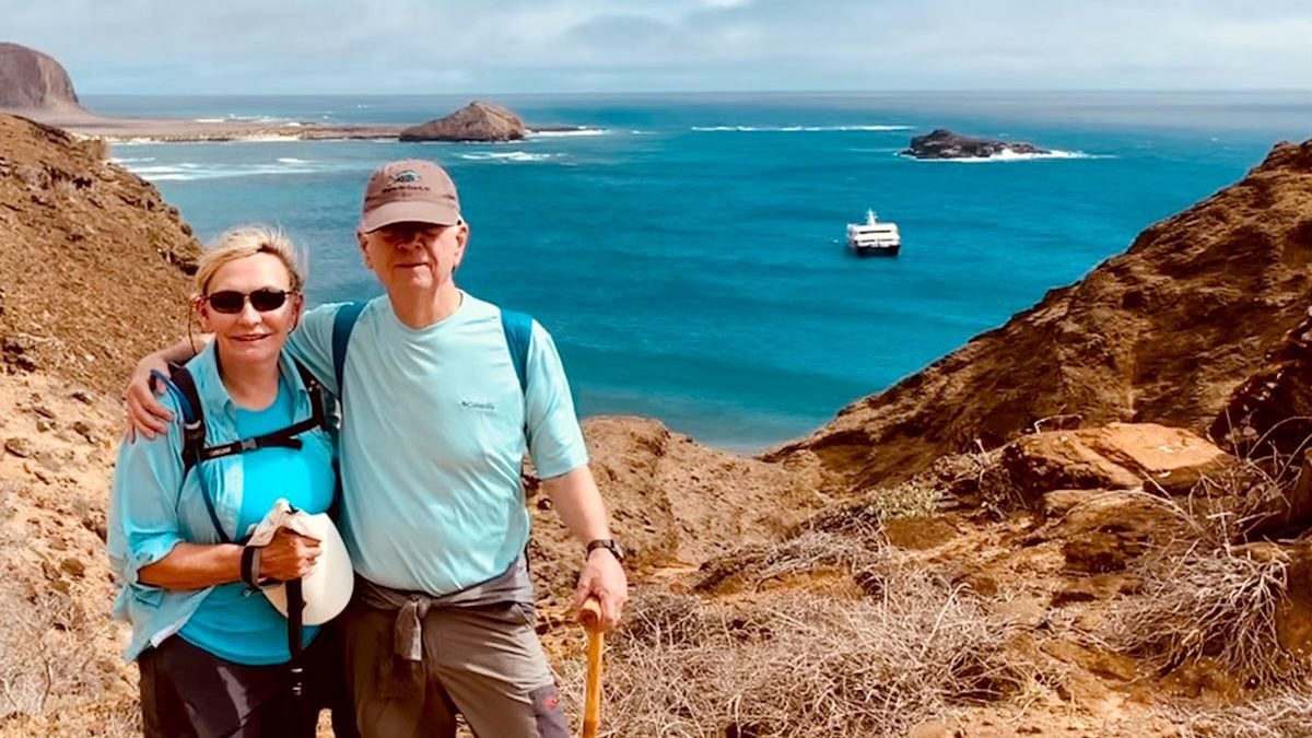 Two people standing near the ocean.