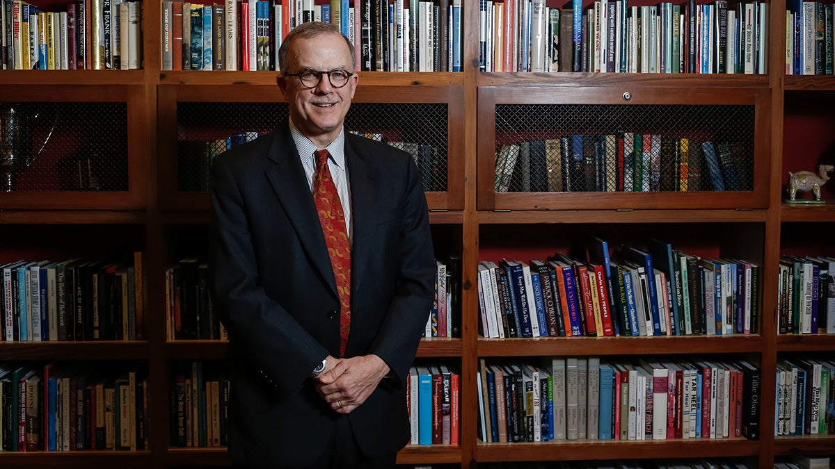 Smith Smith standing by bookshelves.