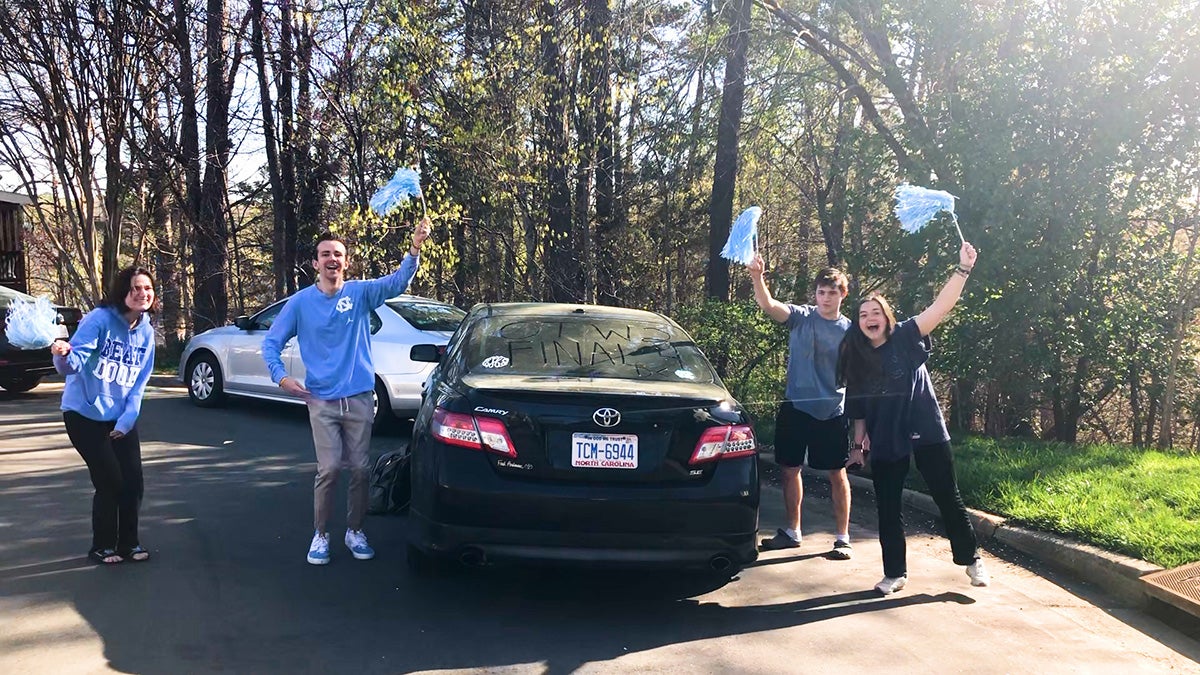 People cheering outside a car.