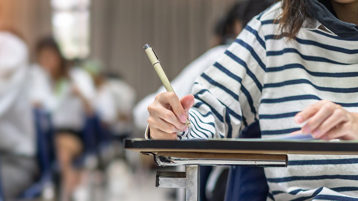 A student writing at a desk.