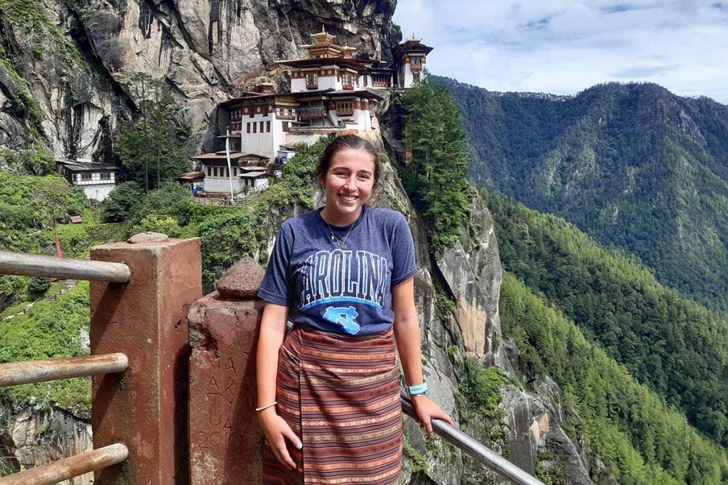 Plauche standing on the steps in a mountain range.
