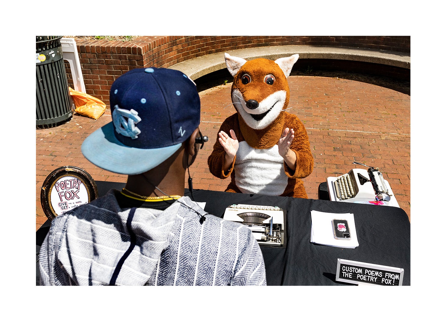 A person talks to a person dressed in a fox costume.