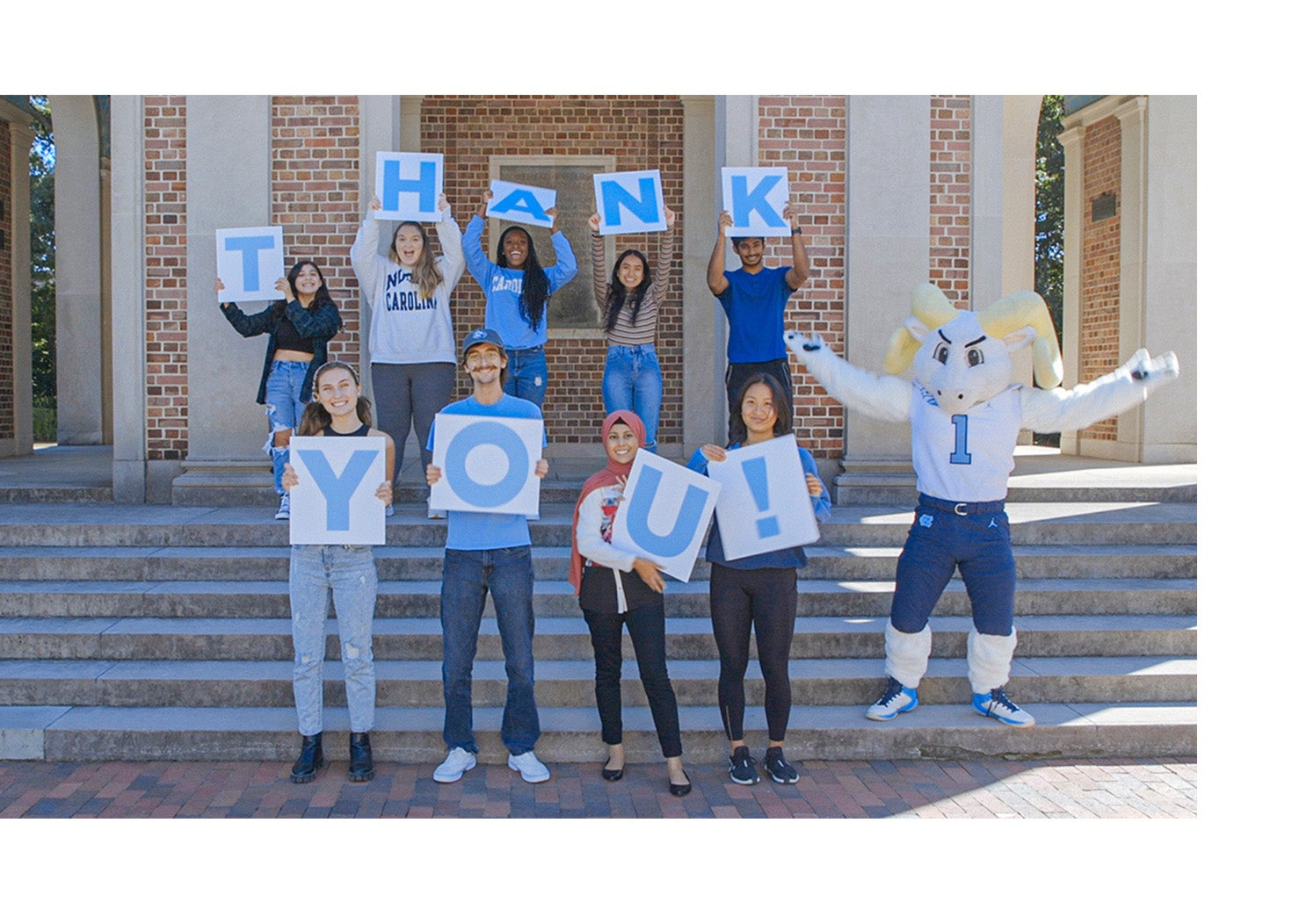 Students holding a sign that says thank you.