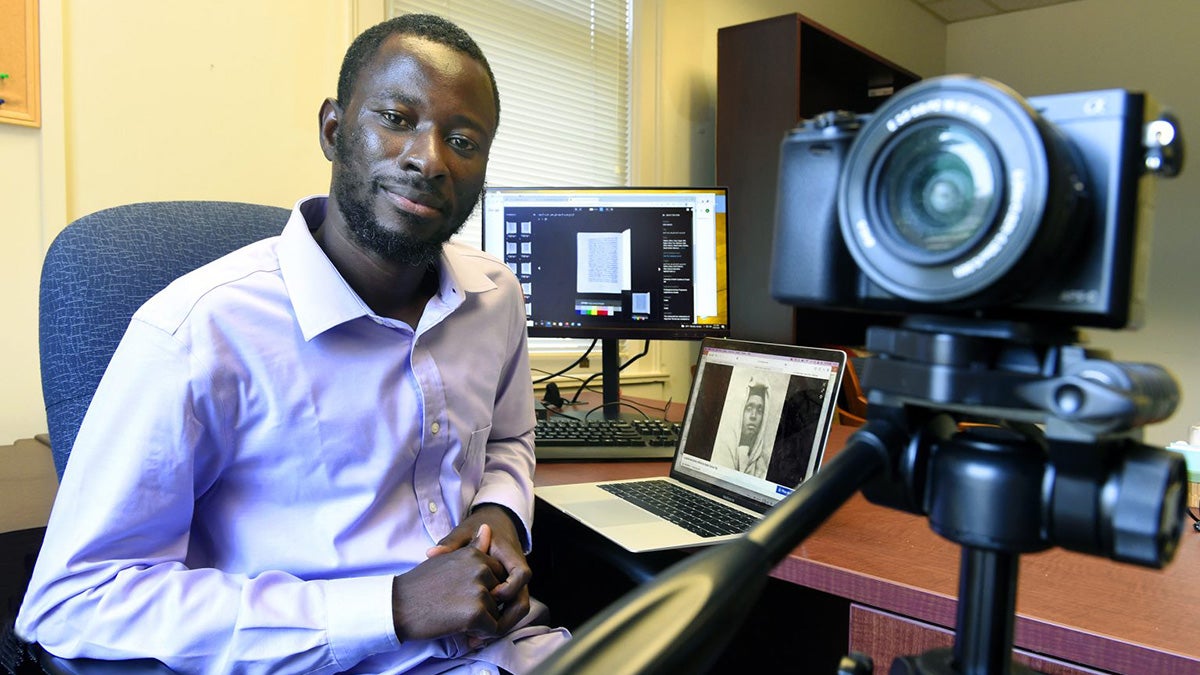Samba Camara sitting at a desk.