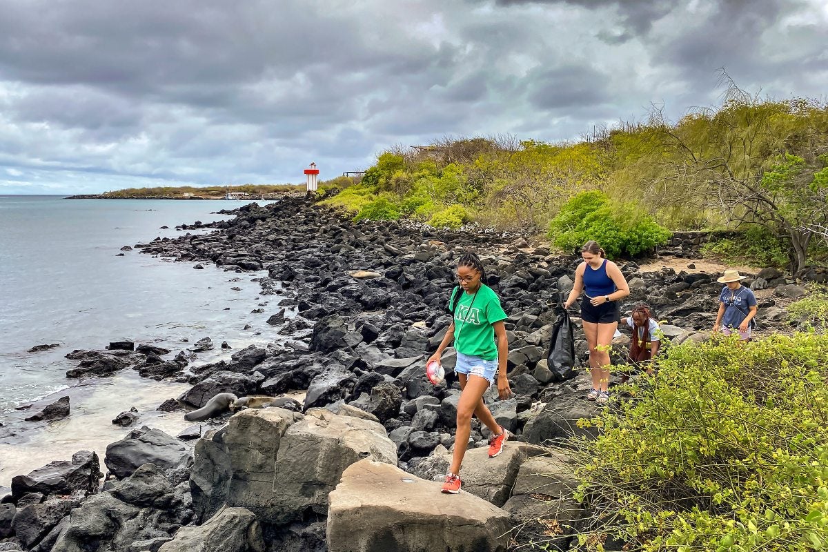 People walking on a rocky beach.