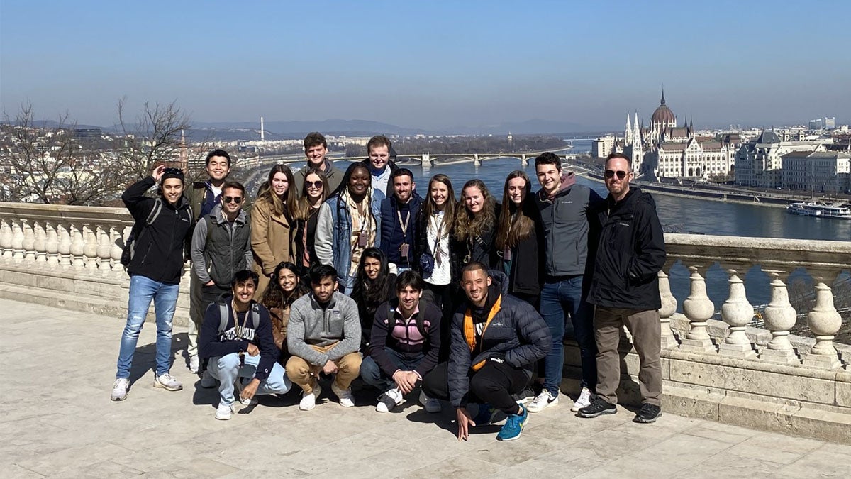 A group of students posing on a bridge.