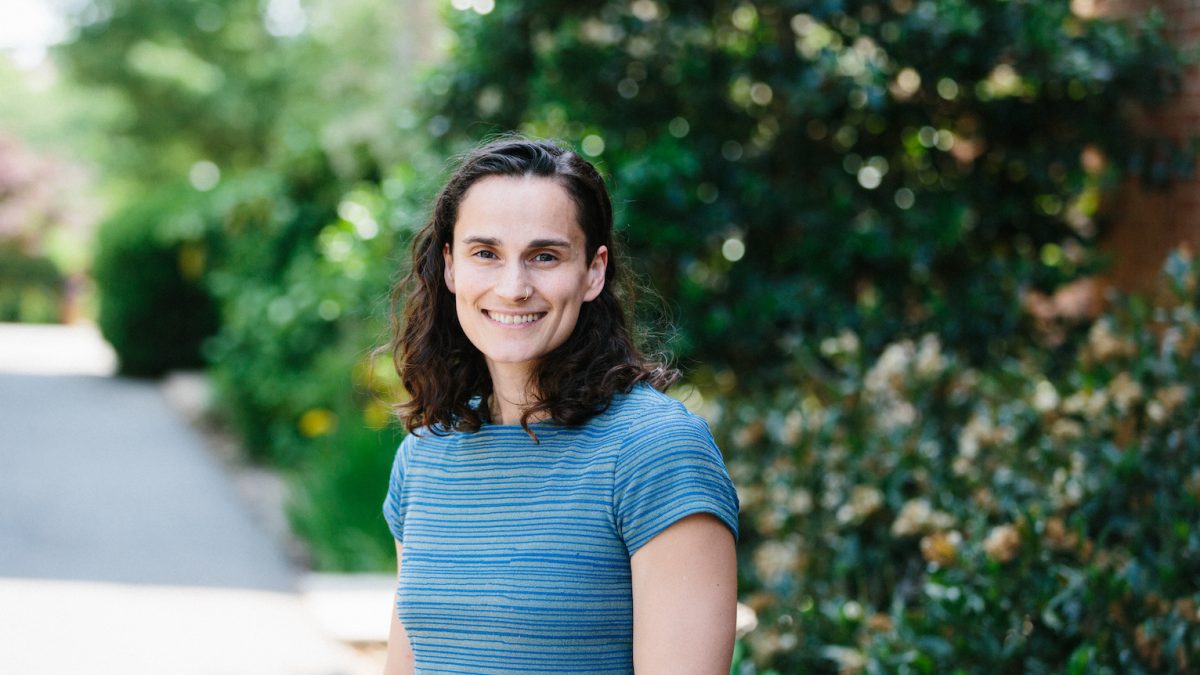 A person smiling in front of trees.
