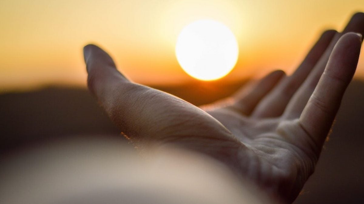Hand and a sun set.