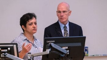 Two people speak in a podium.