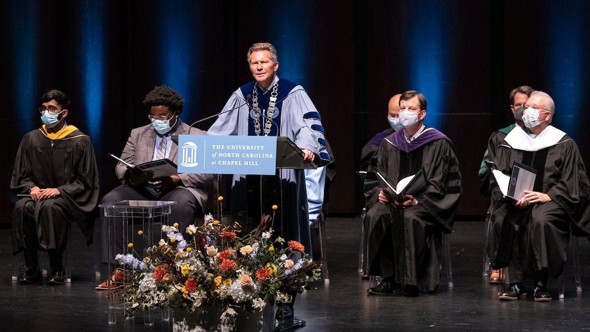 Kevin Guschiewicz on stage with faculty