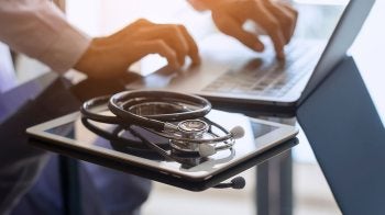 A tablet and a laptop with a stethoscope