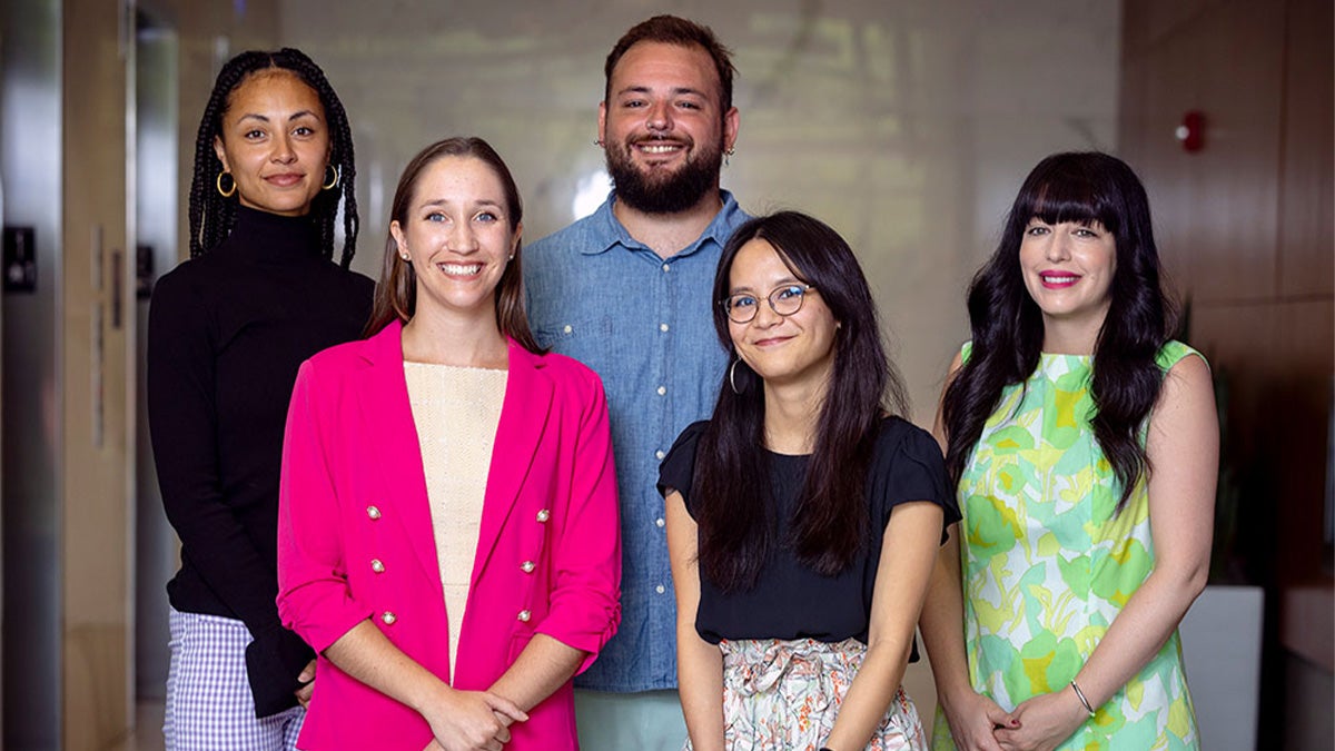 4 women and 1 man all pose for group photo
