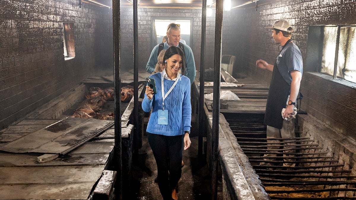 Group of faculty members walk through barbecue facility.
