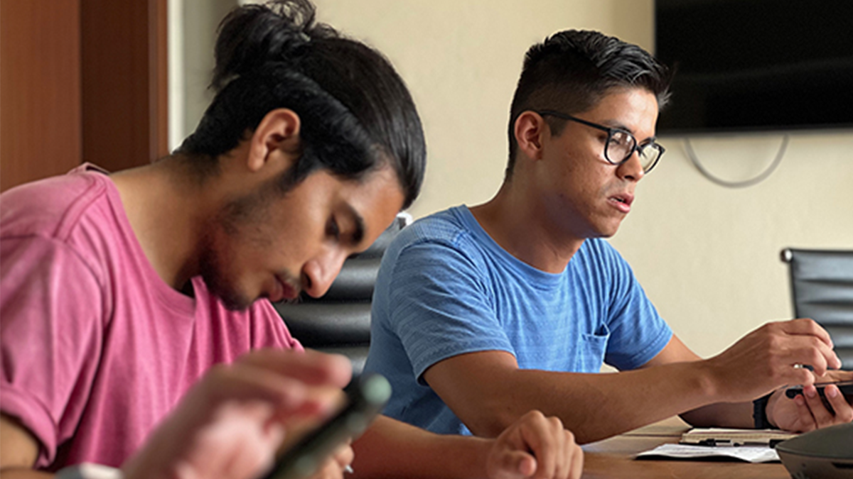 Two individuals looking at paperwork at a conference table.