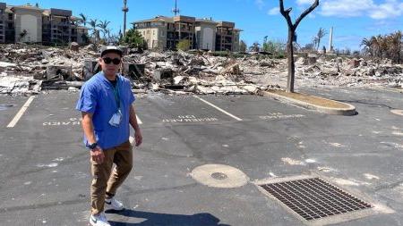 David Kim standing in front of devastation in Maui.