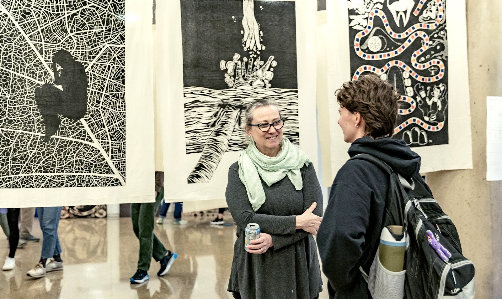 Two people talking at an art show.