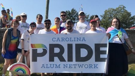 Group of individuals holding sign reading 