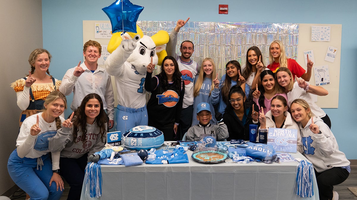 Craniofacial team poses at table with birthday cake