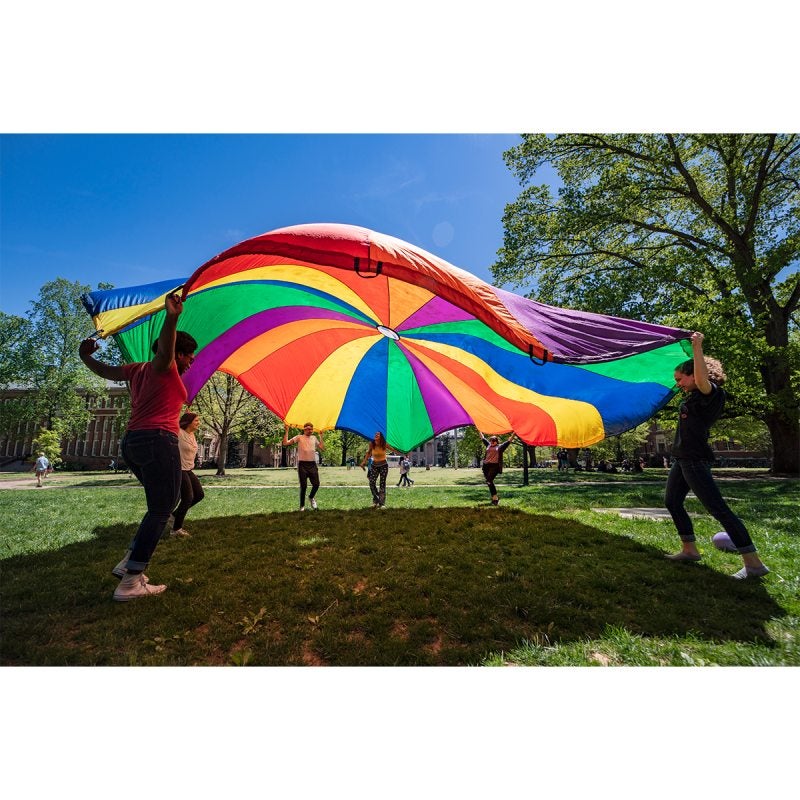 Group of people with rainbow-colored tarp