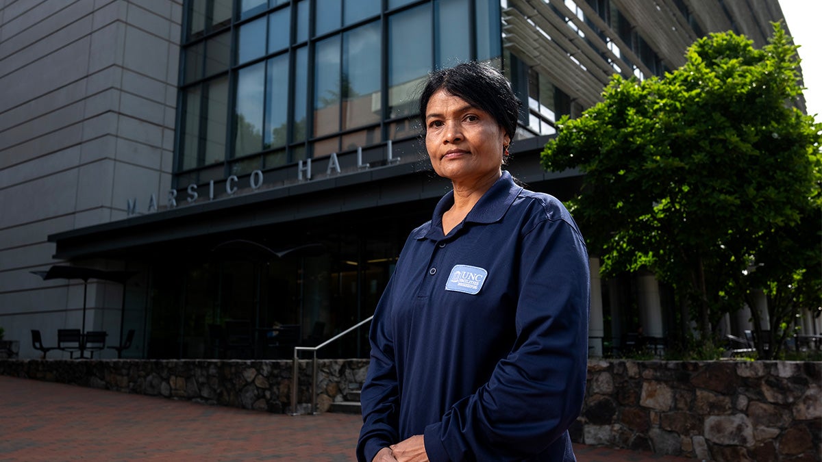 Khin Su Su Kyi posing in front of building exterior.