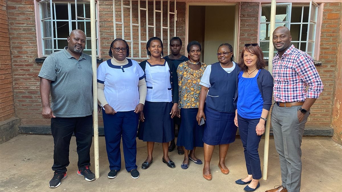 Arlene Sena standing next to individuals who work at an STI clinic.
