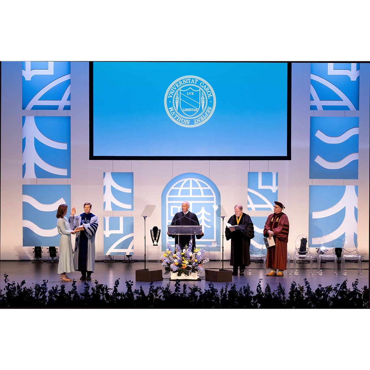 Wide-angle shot of the stage in Memorial Hall on the campus of UNC-Chapel Hill during the inauguration of Chancellor Lee H. Roberts on University Day. Roberts is seen taking his oath of office with his hand on the Bible.
