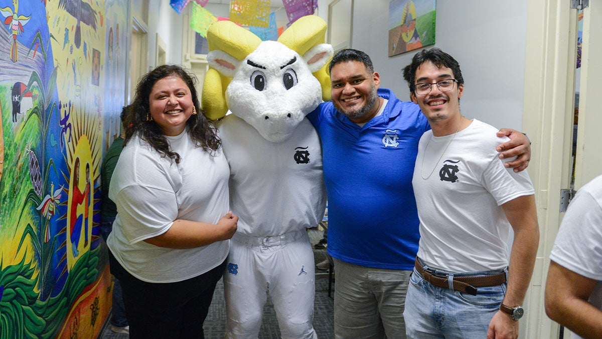 Members of the Latinx community pose for a photo with Rameses in the middle.